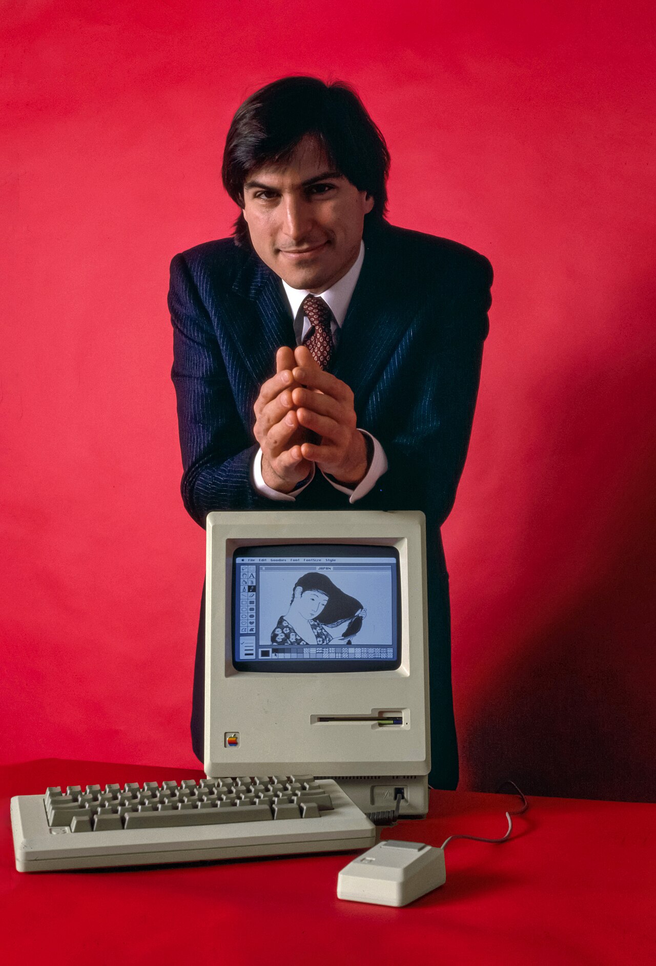 The Jobs Apocalypse Is Postponed: An AI Jobs Boom Is Here — Steve Jobs and Macintosh computer, January 1984, by Bernard Gotfryd - edited