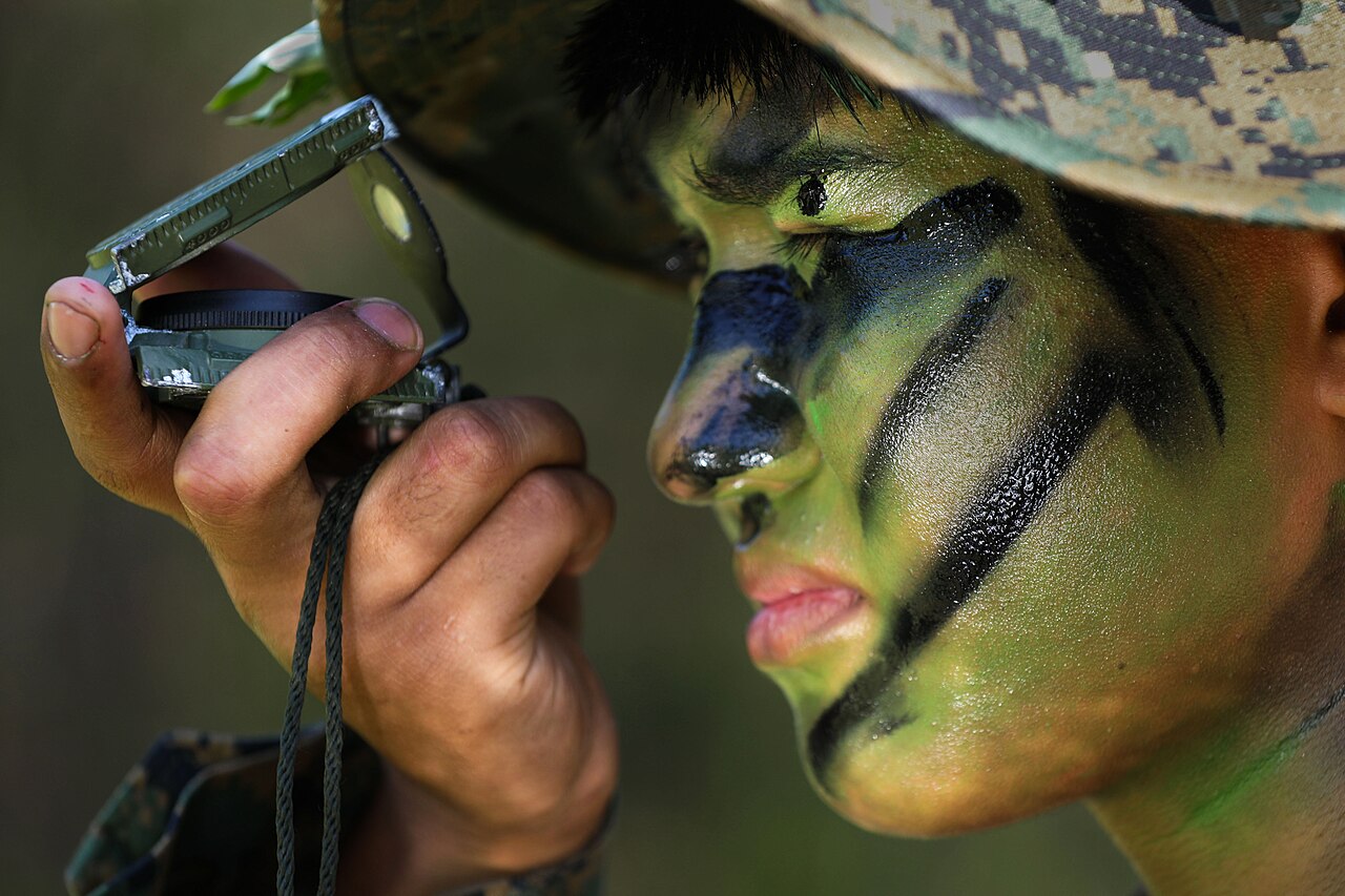 Navigating the Fragmented Landscape of AI Coding Agent Usage Limits — US Marine wearing camo face paint navigating with a compass