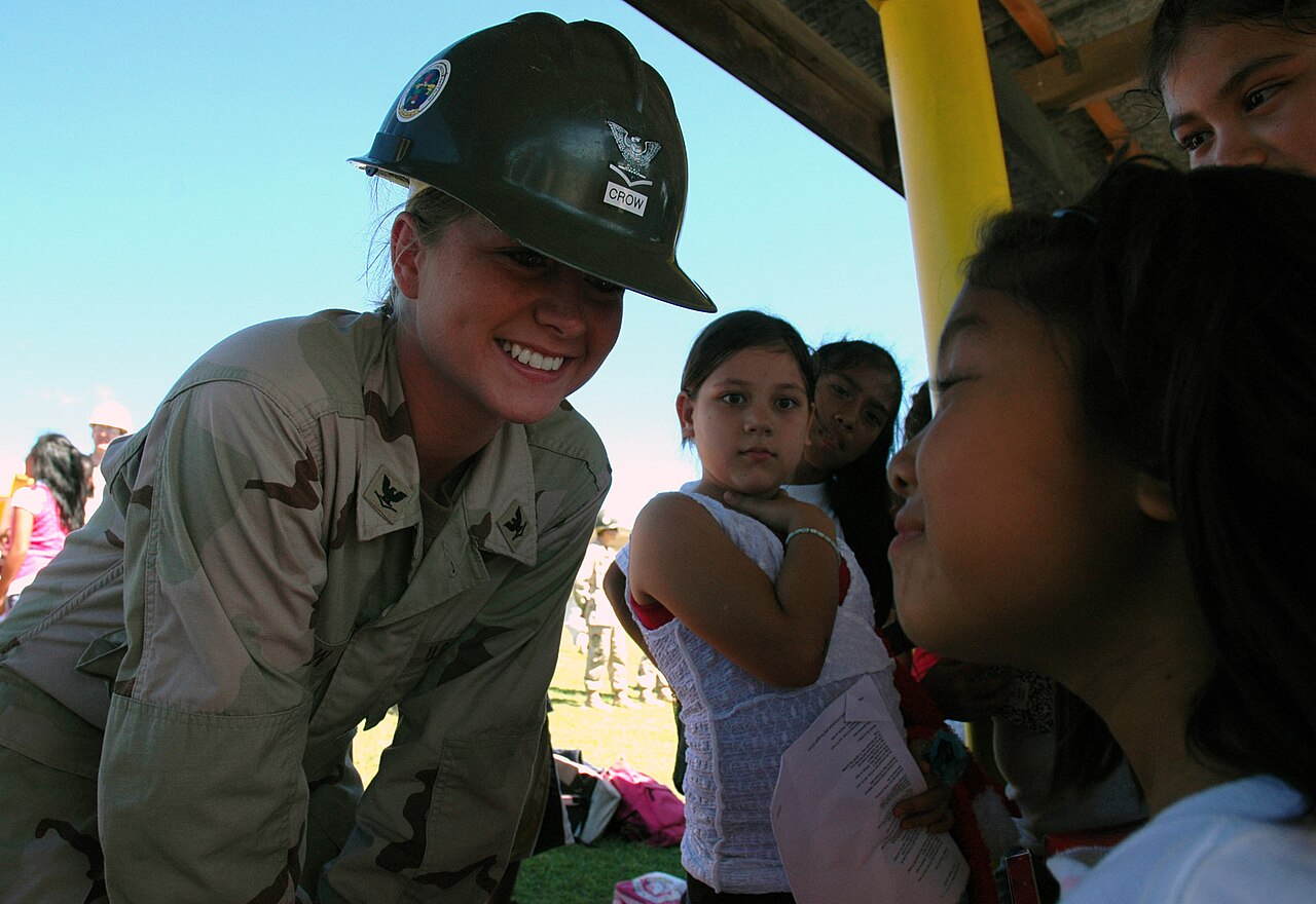 Builder Shares Kling Workflows for Turning Product Photos Into UGC Ads — US Navy 071218-N-7367K-005 Builder 3rd Class Taylor Crow, a Seabee attached to Mobile Construction Battalion (NMCB) 1, Guam Det., shares a moment with a student at Chief Brodie Memorial Elementary School